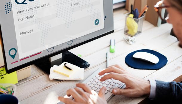  A person focused on typing on a laptop computer, with hands positioned over the keyboard.