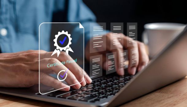 Person typing on a laptop with a digital overlay displaying a "Certificate Passed" badge and floating document icons, representing online certification, compliance, or digital training completion.