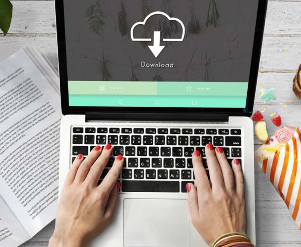 Person typing on a laptop, illustrating the process of downloading data