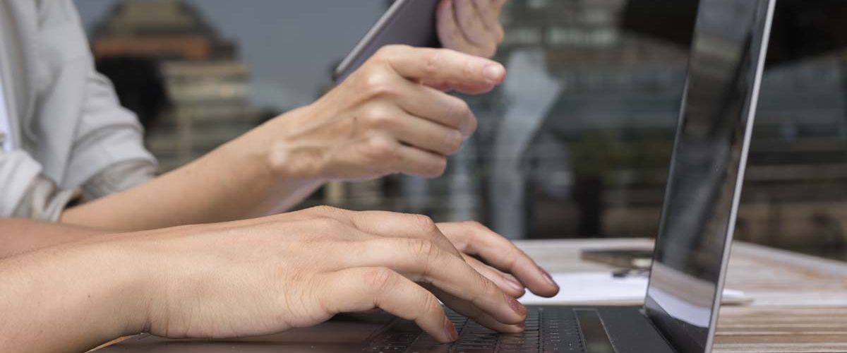 Person typing on a laptop, illustrating the process of downloading data